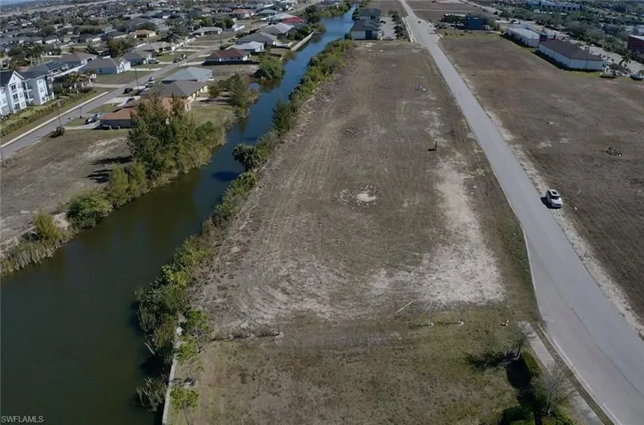 Aerial view of property and surrounding area with a nearby body of water