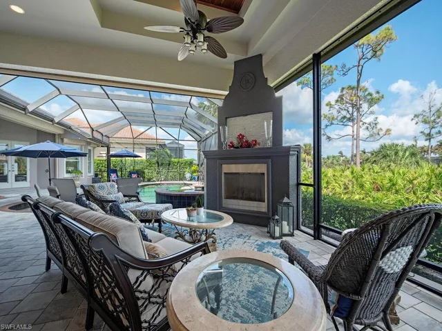 Beautiful outdoor fireplace with seating area, next to the pool