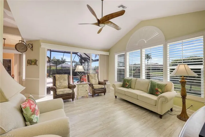 Overlooking the pool and lake, this family room/den offers vaulted ceilings and stunning views.