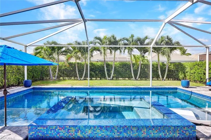 View of inviting pool featuring a fenced yard and lots of tropical landscaping for your privacy.