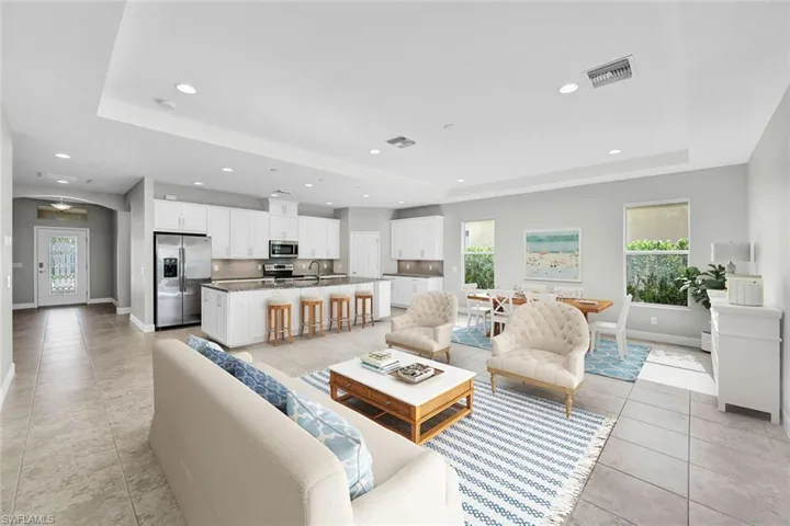Great room has tile flooring, a tray ceiling, and a healthy amount of sunlight. Great for entertaining family and friends all in one space. This room has been virtual staged.