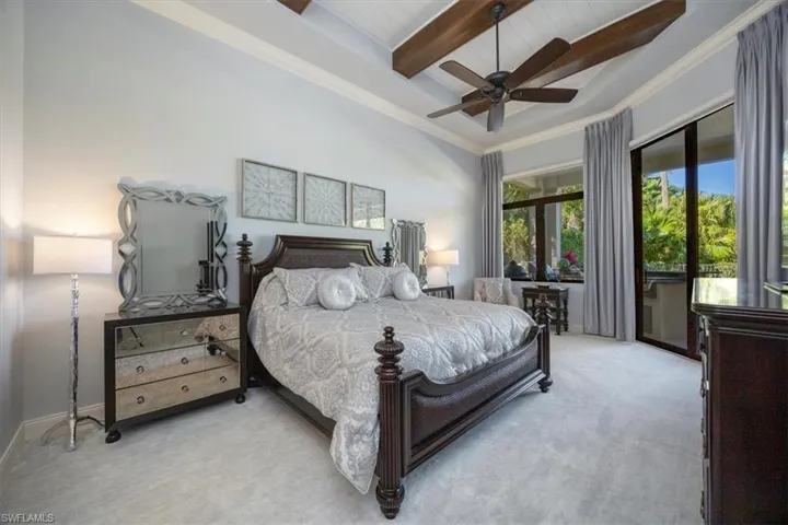 Bedroom with beamed ceiling, access to outside, carpet floors, ornamental molding, and a ceiling fan