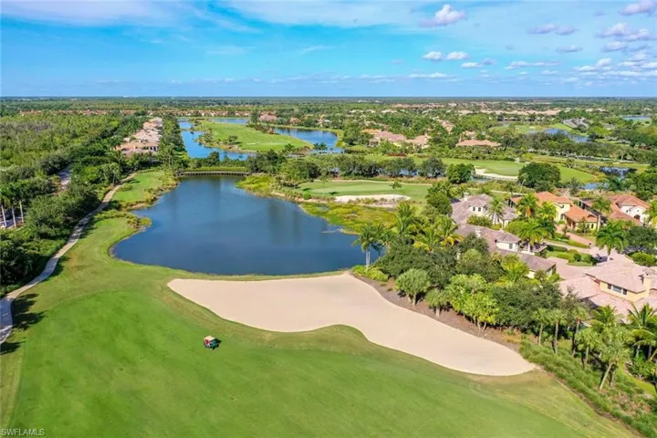 Aerial view of residential area featuring a golf course and a nearby body of water