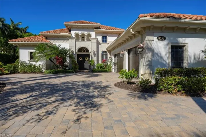 View of front of house with a tiled roof, a garage, and stucco siding