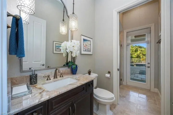 Half bath with stone tile flooring and vanity