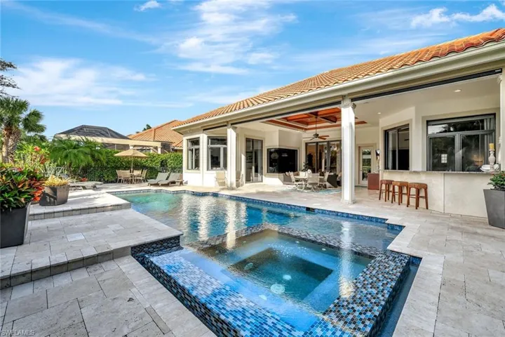 View of pool with outdoor dining area, a patio, ceiling fan, and a pool with connected hot tub