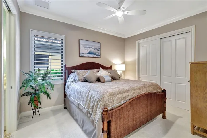 Bedroom featuring ornamental molding, a closet, carpet, and ceiling fan