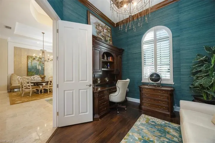 Office with a chandelier, wallpapered walls, crown molding, and dark wood finished floors