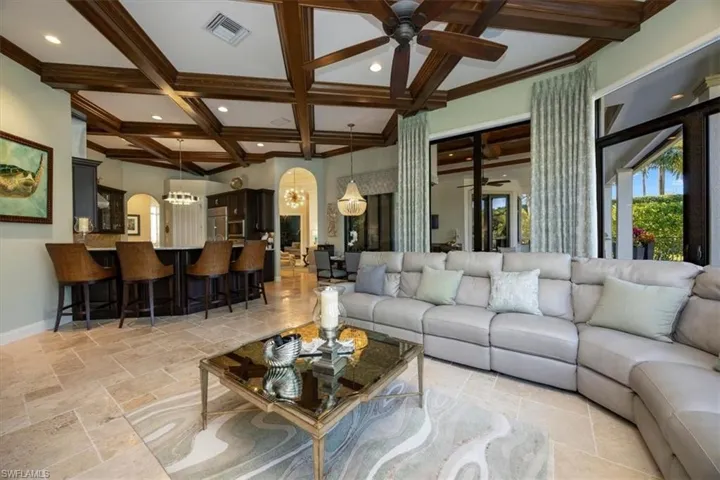 Living room featuring a ceiling fan, coffered ceiling, beam ceiling, a chandelier, and recessed lighting