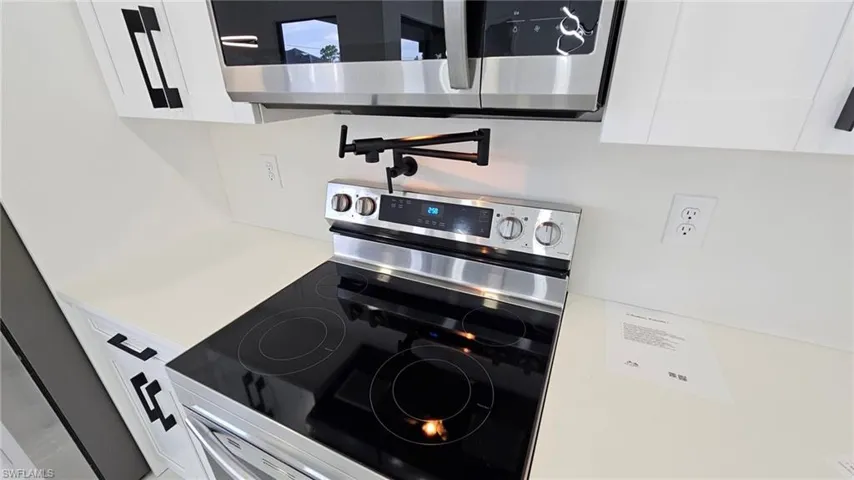 Kitchen featuring stainless steel appliances and white cabinetry