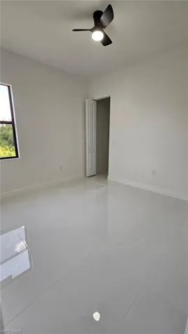 Unfurnished room featuring ceiling fan and light tile patterned flooring