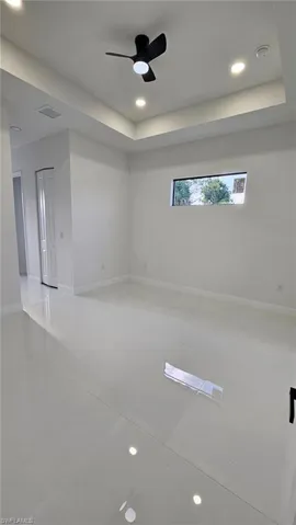Unfurnished room with recessed lighting, a raised ceiling, and a ceiling fan
