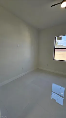 Spare room with baseboards and a ceiling fan