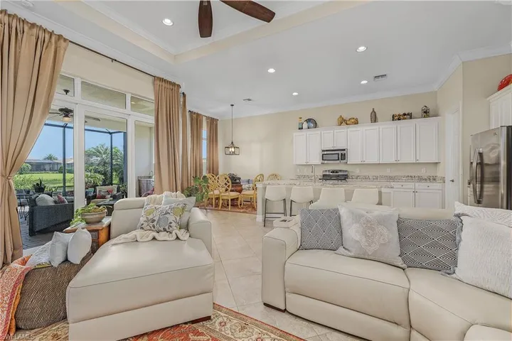 Tiled living room with ceiling fan and crown molding