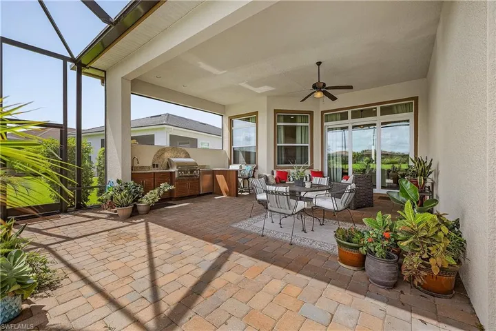 View of patio with a lanai, area for grilling, an outdoor kitchen, and ceiling fan