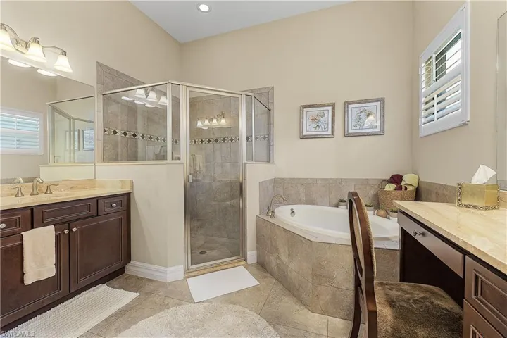 Bathroom with vanity, tile patterned floors, and shower with separate bathtub
