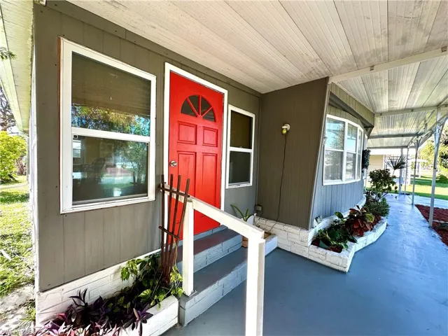 Doorway to property featuring covered porch