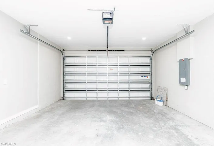 Garage with electric panel and a garage door opener