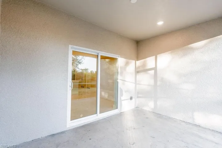 Spare room with a textured wall, unfinished concrete floors, and recessed lighting