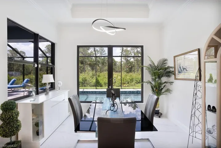 Tiled dining area featuring a tray ceiling and crown molding