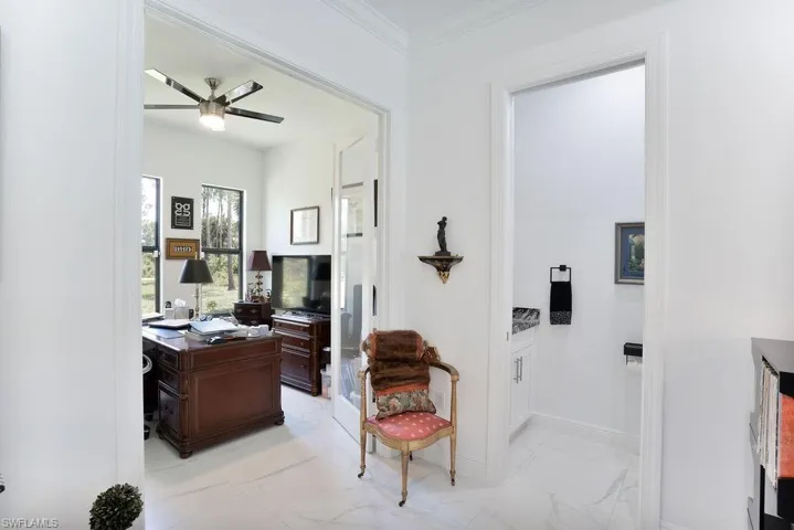View of the study and corridor featuring ornamental molding and light tile flooring