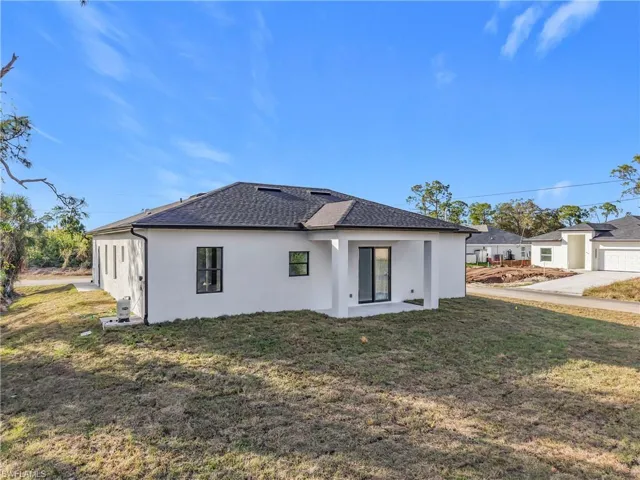 Back of property featuring a lawn and a patio area