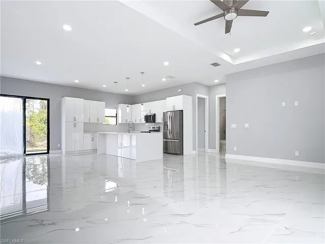 Kitchen featuring white cabinetry, pendant lighting, stainless steel appliances, and a center island