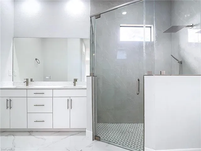 Bathroom with vanity and a shower with door