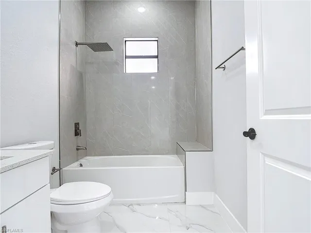 Full bathroom featuring vanity, bathtub / shower combination, and toilet
