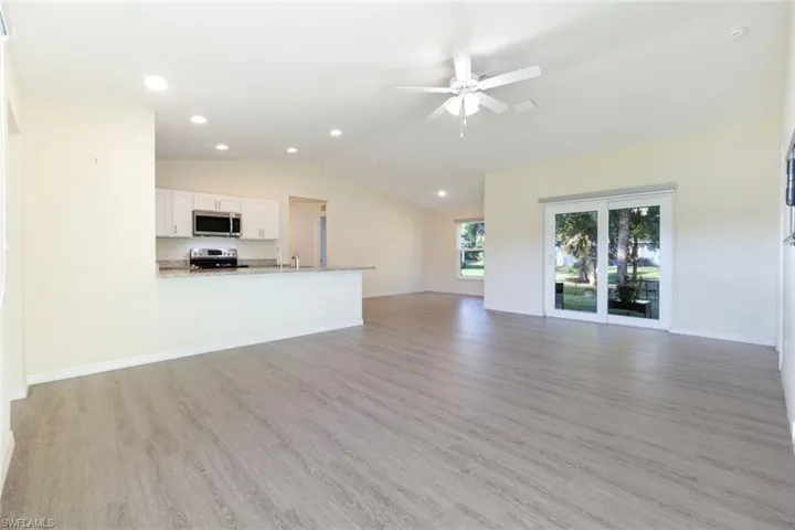 Unfurnished living room featuring light wood finished floors, vaulted ceiling, recessed lighting, and a ceiling fan