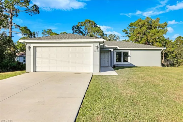 Single story home with stucco siding, a front lawn, driveway, an attached garage, and a shingled roof