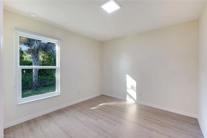 Unfurnished room with light wood-style flooring and baseboards