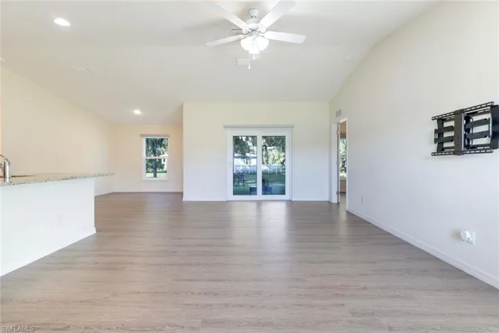 Empty room with recessed lighting, lofted ceiling, light wood-type flooring, and ceiling fan