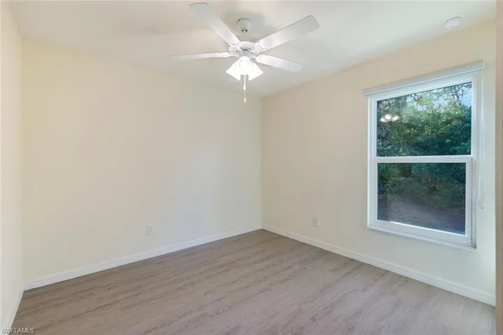 Spare room with wood finished floors and a ceiling fan