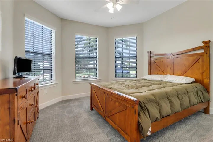 Bedroom featuring light colored carpet and a ceiling fan