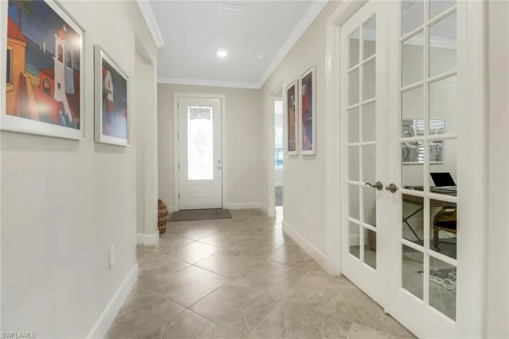 Entrance foyer with crown molding and french doors