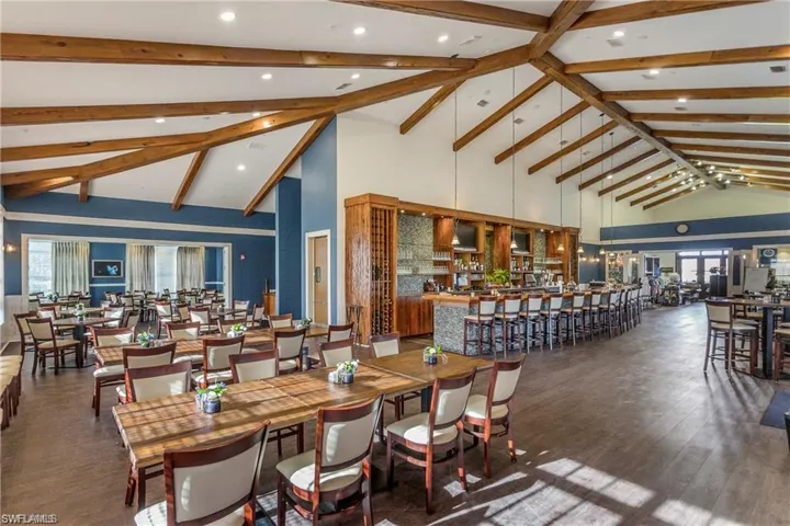 Dining room featuring high vaulted ceiling, beam ceiling, wood finished floors, and recessed lighting