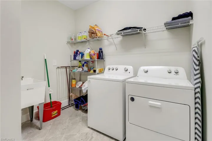 Laundry area with separate washer and dryer and light tile patterned floors