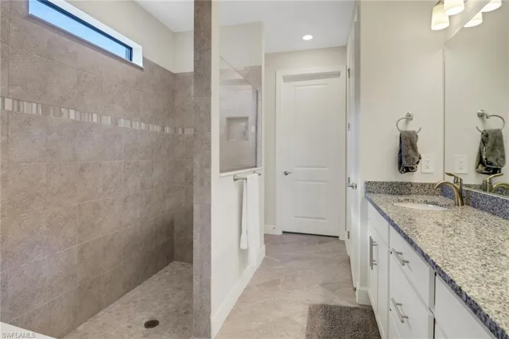 Bathroom featuring a walk in shower and vanity