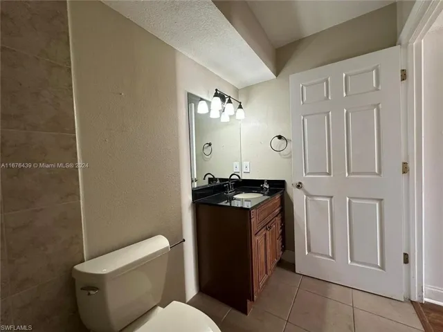 Bathroom featuring vanity, toilet, and tile patterned floors