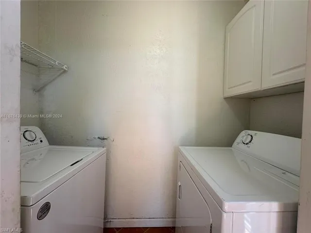 Laundry room featuring cabinets, tile patterned flooring, and independent washer and dryer