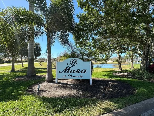 Surrounding community with a water view and a lawn