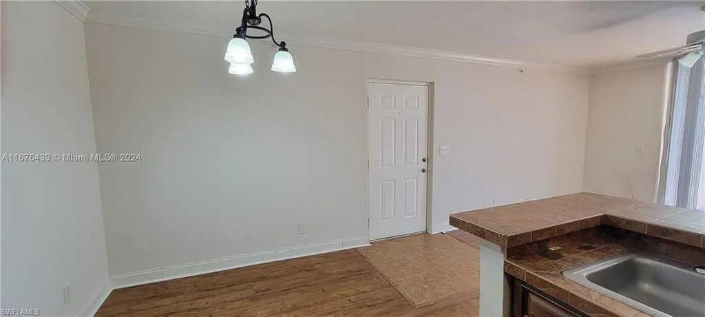 Unfurnished dining area with crown molding and hardwood / wood-style floors