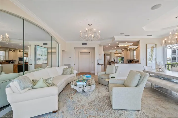 Tiled living room featuring ornamental molding and a chandelier