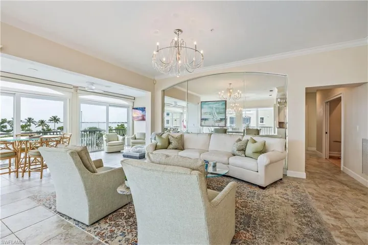 Tiled living room featuring crown molding and an inviting chandelier