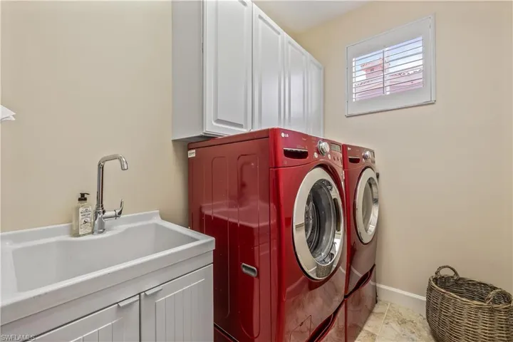 Washroom with sink, cabinets, light tile patterned floors, and independent washer and dryer