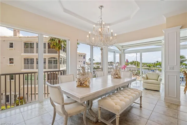 Tiled dining room with a chandelier and a tray ceiling