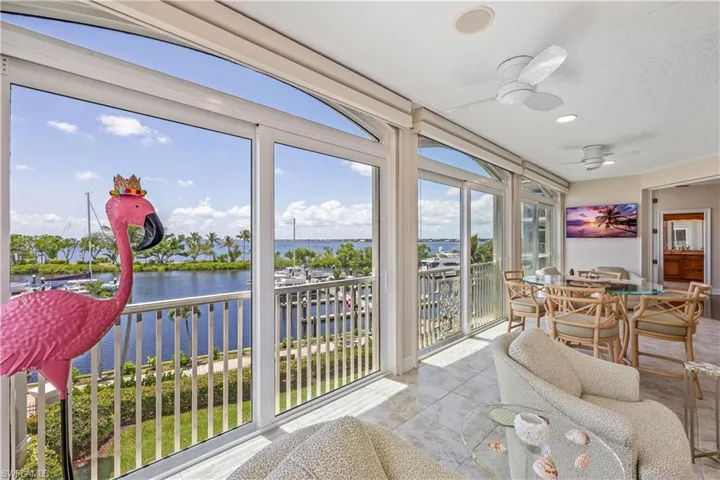 Sunroom featuring a healthy amount of sunlight, a water view, and ceiling fan