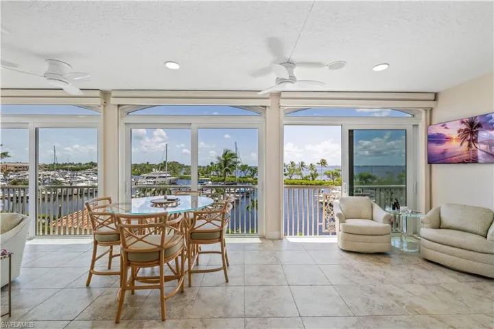 Dining area with a textured ceiling, light tile patterned floors, a wealth of natural light, and ceiling fan
