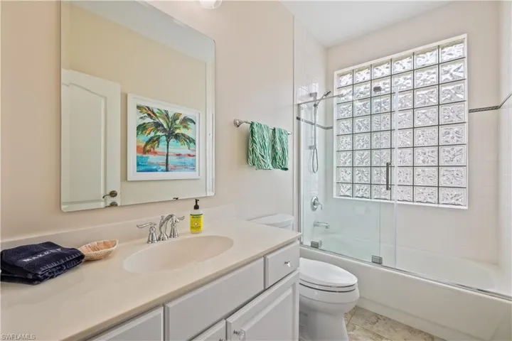 Full bathroom featuring vanity, tile patterned flooring, bath / shower combo with glass door, and toilet